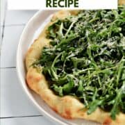 Pizza topped with with arugula greens and grated parmesan with title graphic across the top.