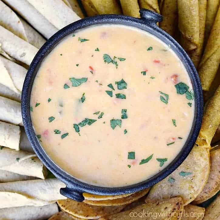 queso blanco dip surrounded by taquitos and min tacos