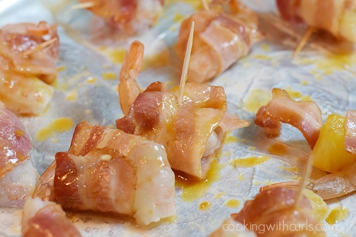 Bacon wrapped shrimp stuck together with toothpicks and brushed with teriyaki sauce. 