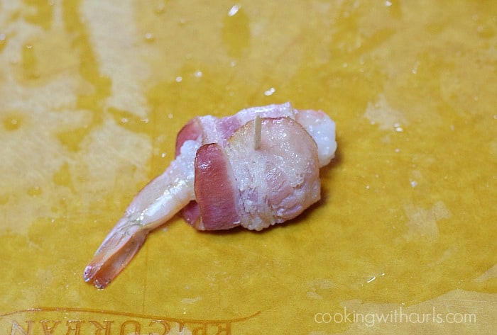 Bacon wrapped around a shrimp with a toothpick holding it together.