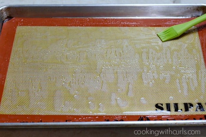 A baking sheet with silicone liner brushed with olive oil.