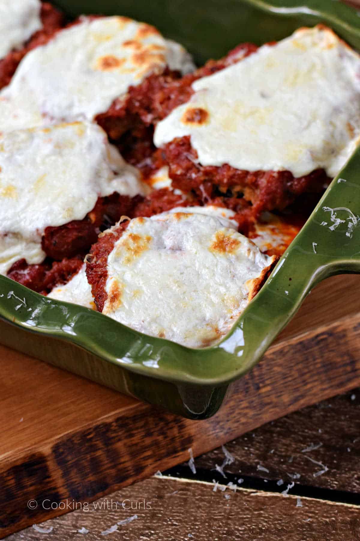 Eggplant parmesan topped with melted cheese in a baking dish.