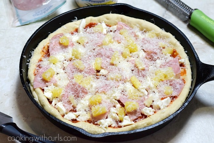 Deep Dish Hawaiian Pizza topped with Parmesan cheese ready to go into the oven.