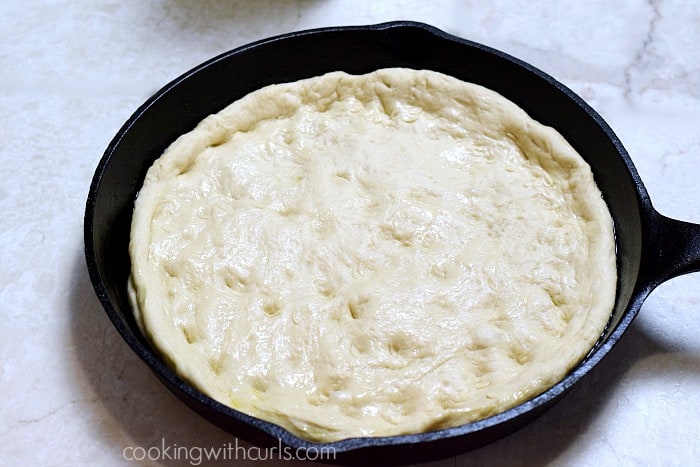 Pizza dough in a cast iron skillet.