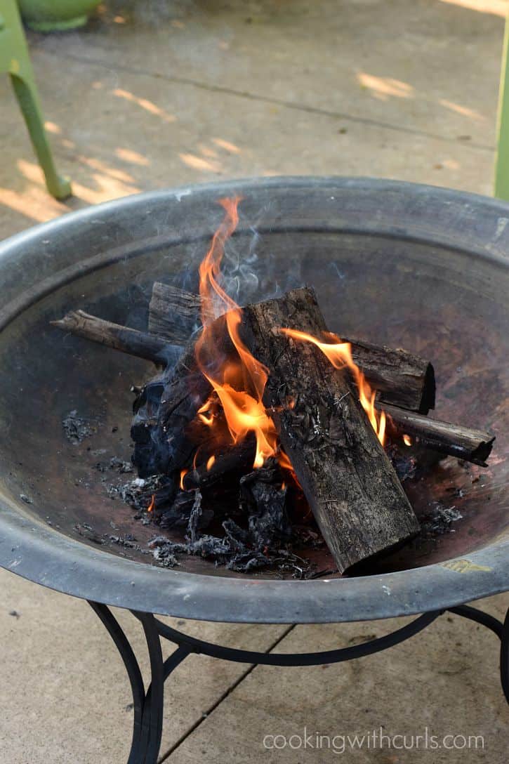 Fire burning in a stack of wood inside a fire pit.
