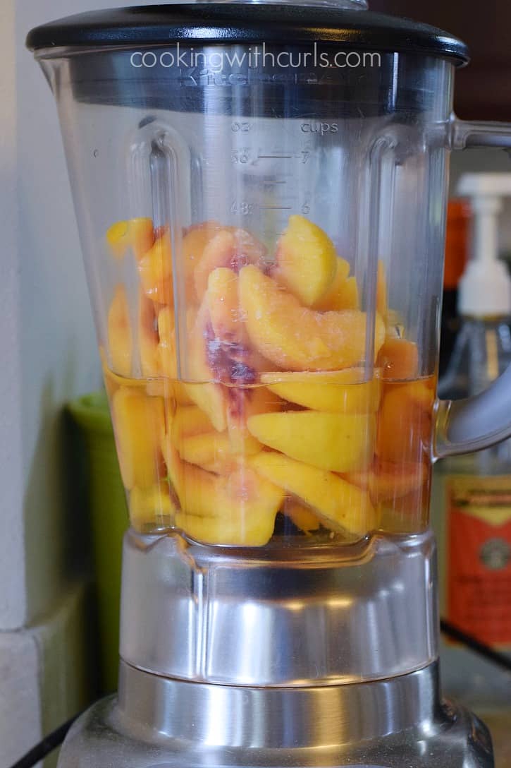 Frozen peaches and white wine in a blender.
