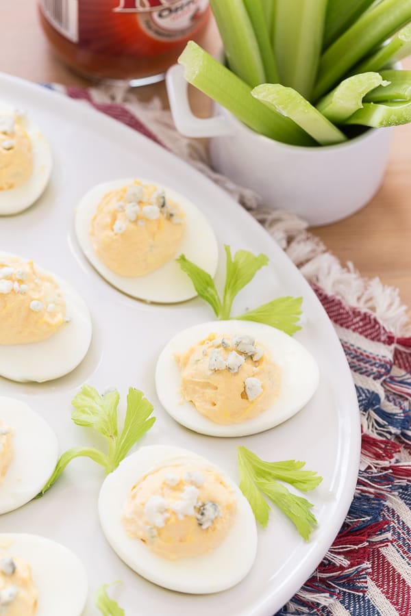 Buffalo Style Eggs with celery on a white egg platter