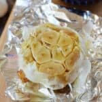 A bulb of roasted garlic on a piece of foil.