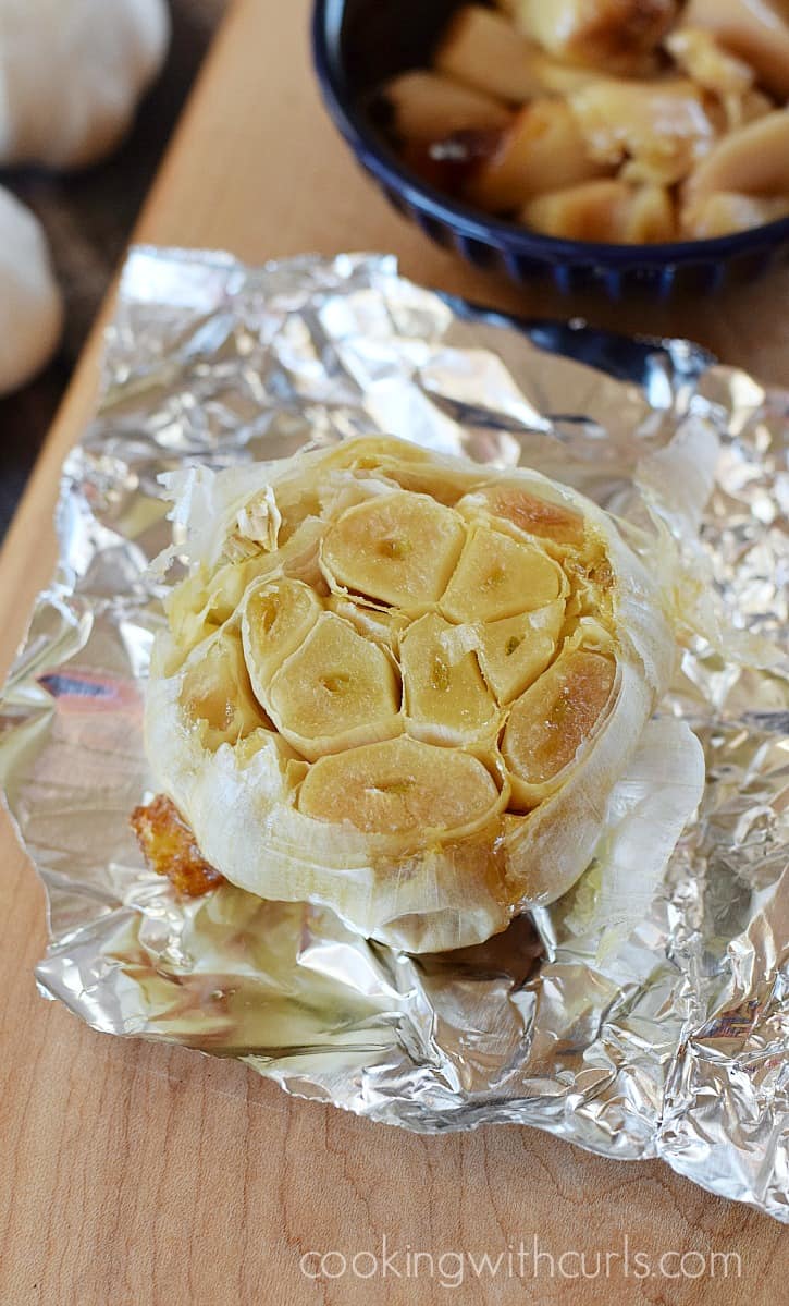A bulb of roasted garlic on a piece of foil.