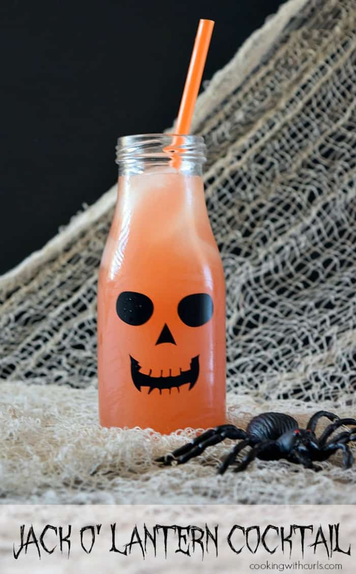 Jack o' Lantern Cocktail with beige netting in the background draped over a black board