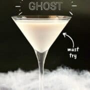 An off-white Liquefied Ghost Martini in a martini glass surrounded by fake spider webs with a black background and title graphic across the top.