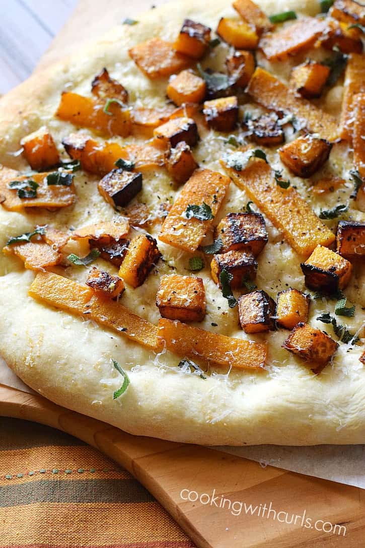 Butternut Squash and Sage Pizza on a wooden pizza peel.
