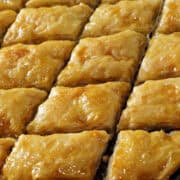 Chocolate baklava cut into a diamond pattern in a rimmed baking sheet.