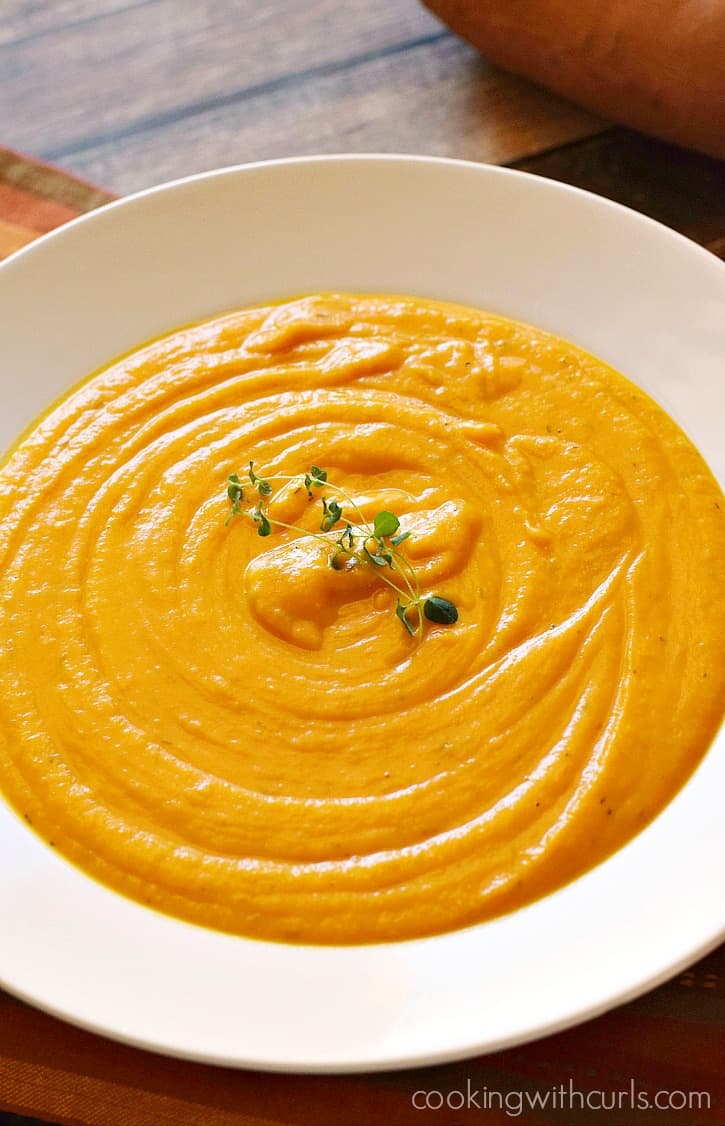a close up image of roasted sweet potato soup in a large white bowl
