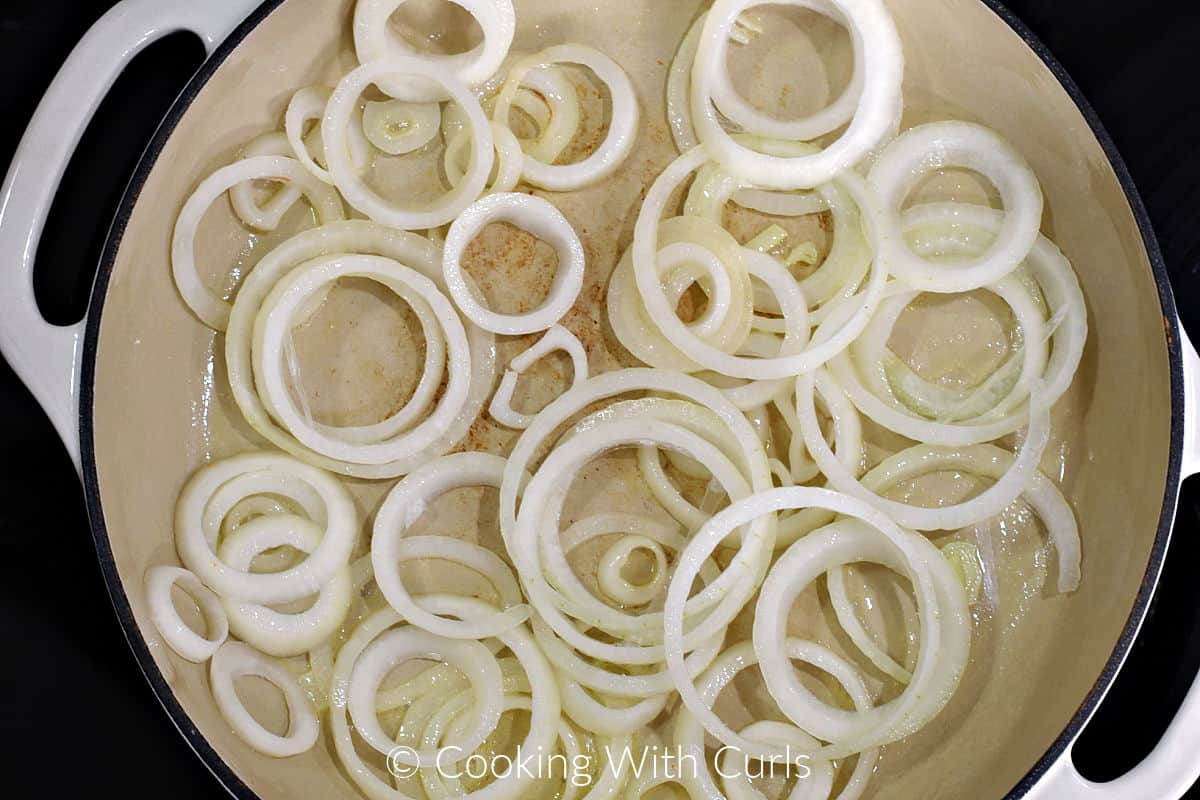 Sliced onion rings in a large skillet. 