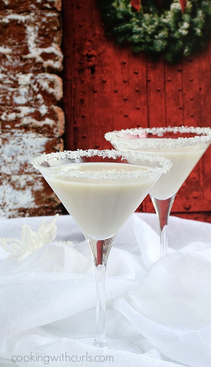 Snowflake Martini in two sugar crystal rimmed martini glasses with a snowy background.