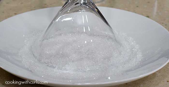 Martini glass dipped into a plate of sugar crystals.