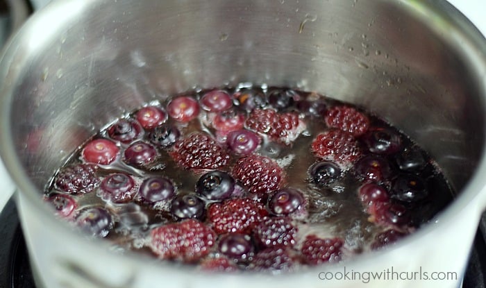 Blackberries, blueberries, and water simmering in a saucepan.