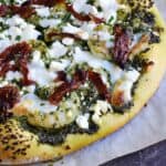 Shrimp Pesto Pizza topped with kale pesto, sun-dried tomatoes, feta and mozzarella cheese on a homemade crust | cookingwithcurls.com