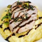 Moist and tender Tuscan Stuffed Pork Loin served on a bed of creamy polenta and drizzled with balsamic glaze that is perfect for any special occasion cookingwithcurls.com #EntertainandPair #ad