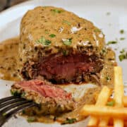 Medium-rare steak au Poivre sliced open to show inside.