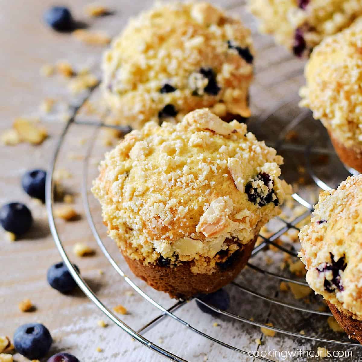 Streusel topped blueberry muffins on a wire cooling rack.