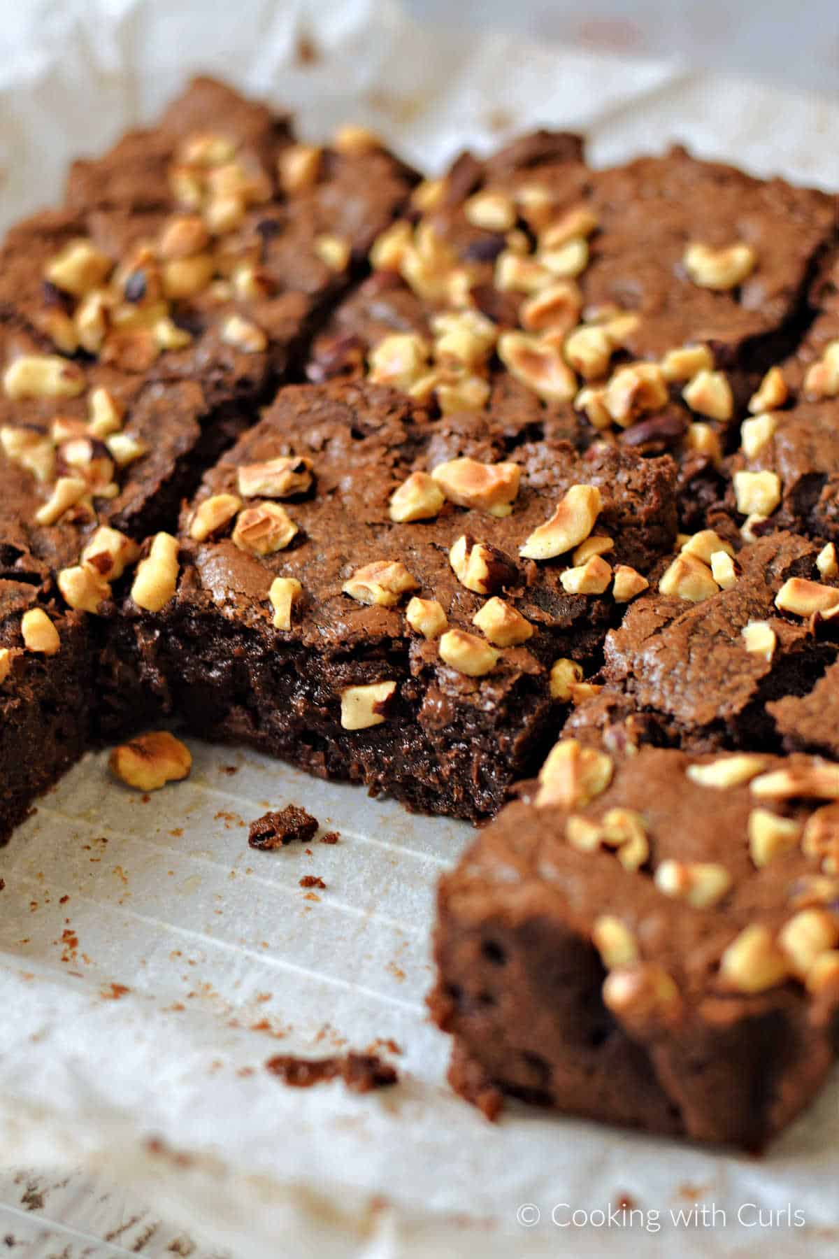 A pan of eight hazelnut brownies with one removed.
