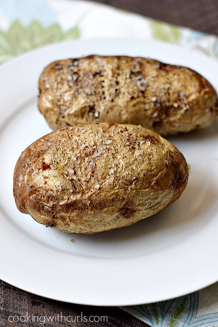 Two baked potatoes on a plate.