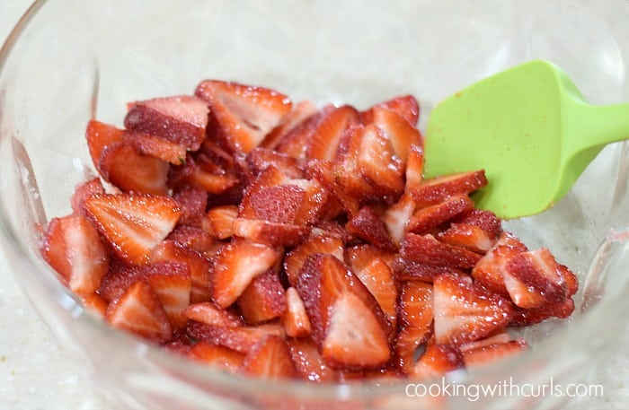Sliced strawberries and sugar in a large mixing bowl.