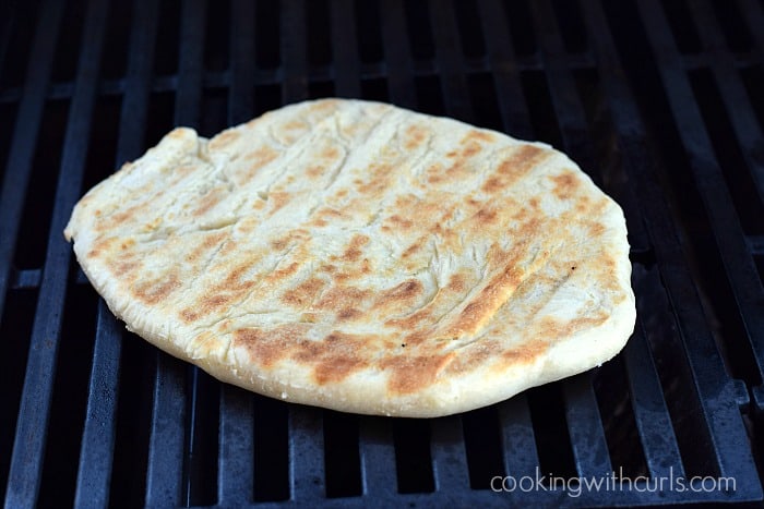 Pizza dough circle grilled on the barbecue grill.