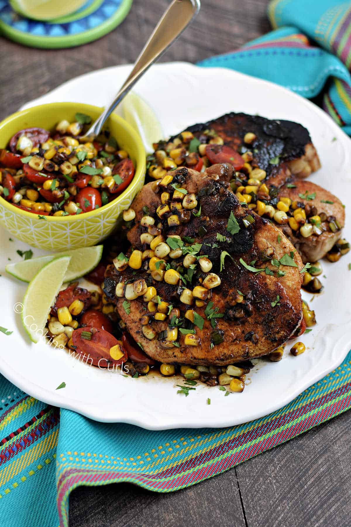 Southwest Pork Chops topped with sweet corn pan sauce, and cherry tomatoes.