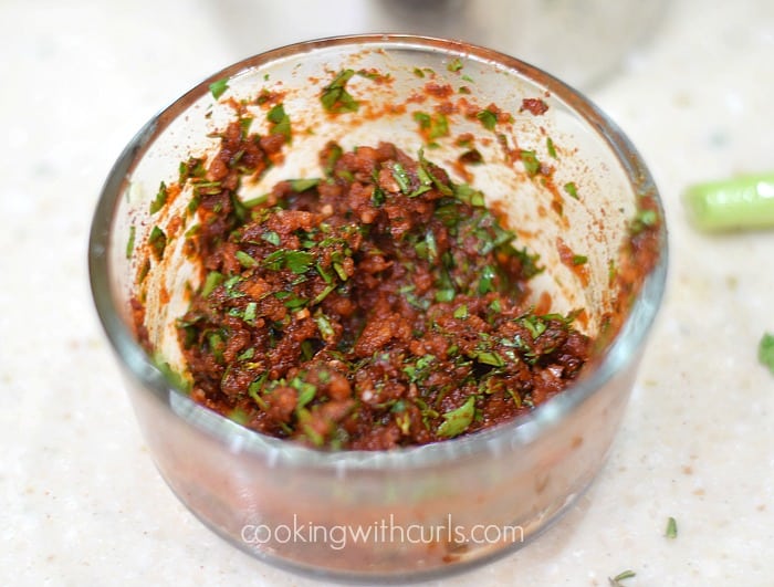 Garlic, thyme, parsley, and paprika mixed together in a small bowl.