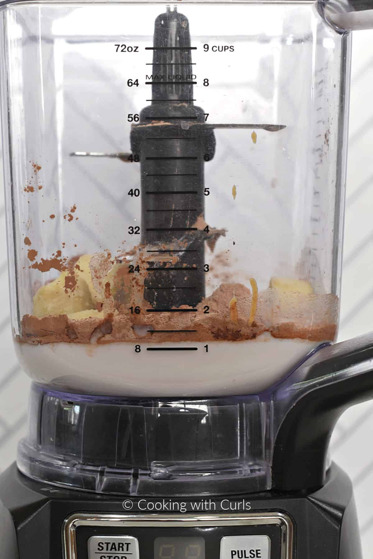 Almond milk, peanut butter, banana slices and chocolate powder in a blender. 