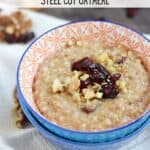 Steel Cut Oatmeal in a small blue bowl topped with walnuts and dried cranberries.