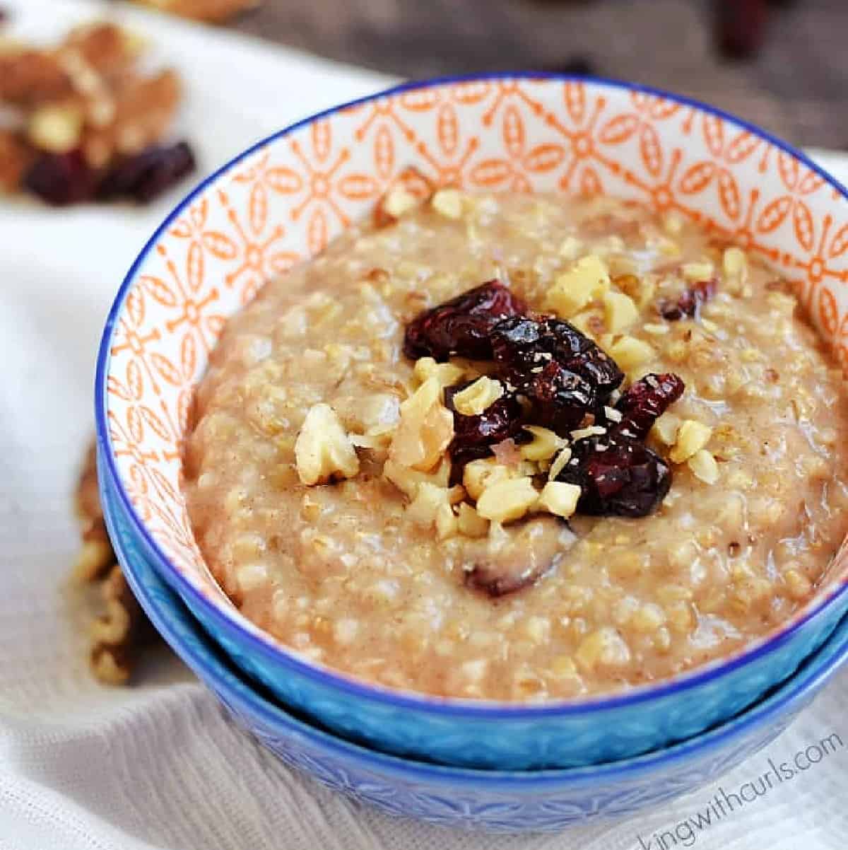 Instant Pot Steel Cut Oatmeal in a small bowl topped with walnuts and dried cranberries.