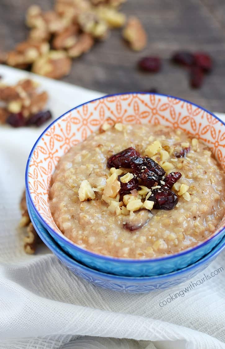 Steel Cut Oatmeal in a small bowl topped with dried cranberries and chopped pecans.