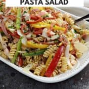 Salami, pepperoni, roasted turkey, bell peppers, and rotini tossed in a light homemade Italian dressing served in a white bowl with title graphic across the top.