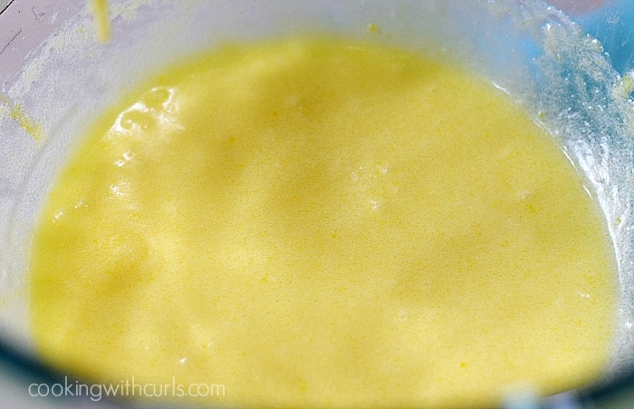 Eggs, butter and sugar mixed together in a mixing bowl.