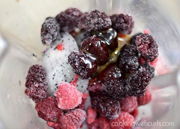 Frozen berries, dragon fruit and honey in a blender.