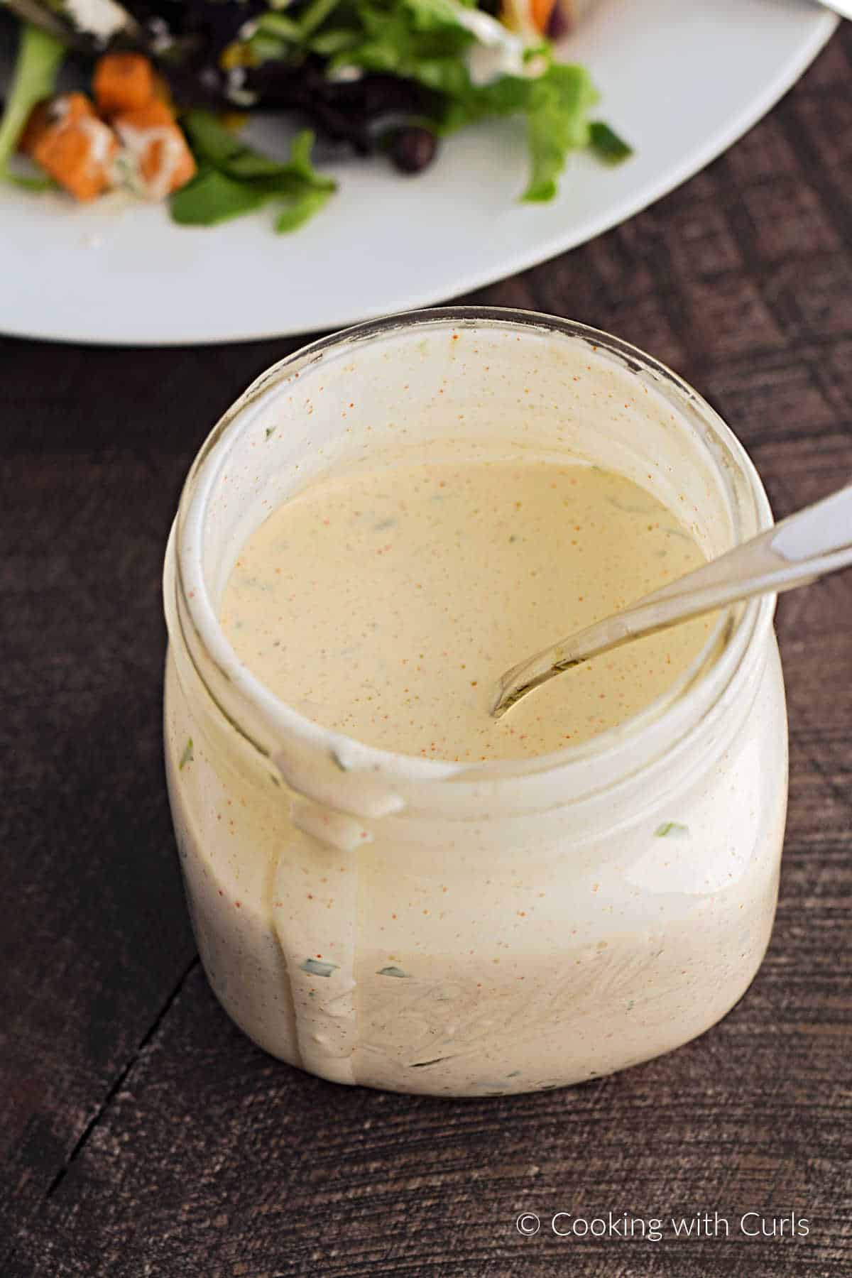 Homemade Chipotle Ranch Dressing in a Mason jar with a spoon sticking out the top of the jar.