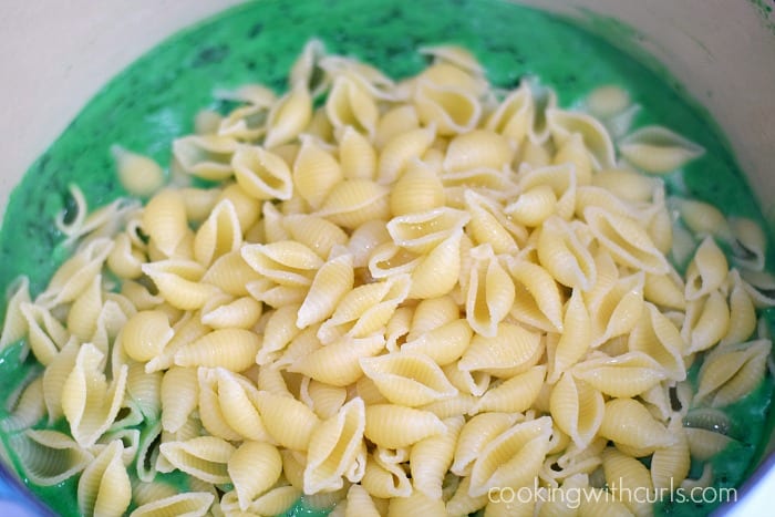 Cooked shell shaped pasta added to the green cheese mixture.