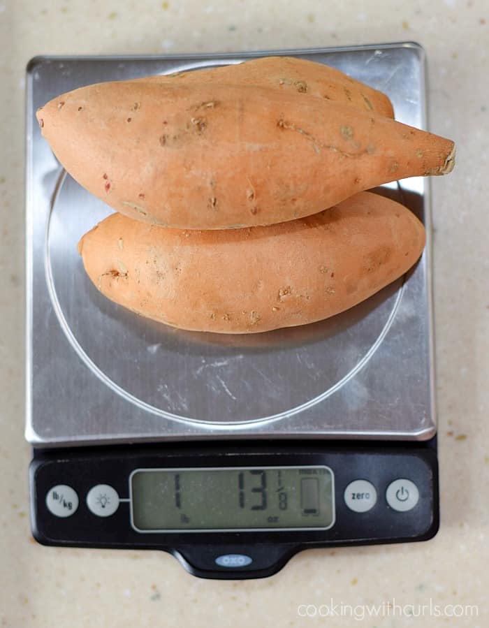 Three sweet potatoes on a scale showing one pound, thirteen and .13 ounces.