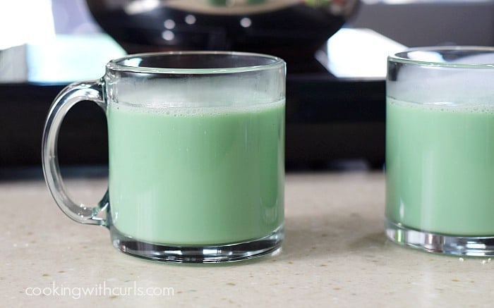 Two glass mugs filled with green hot chocolate.
