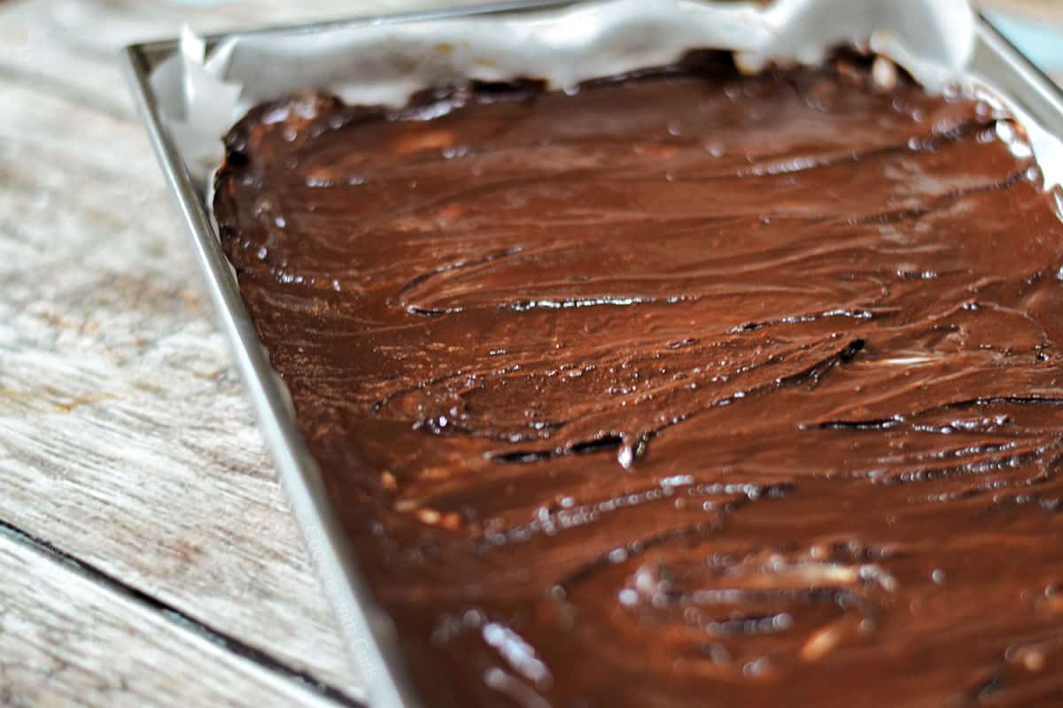 Chocolate ganache topped peppermint brownies in baking pan.