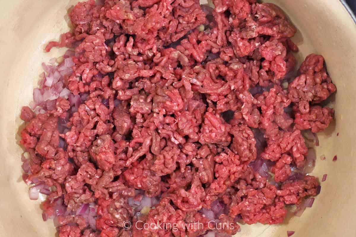 Ground beef added to the cooked onion and garlic.