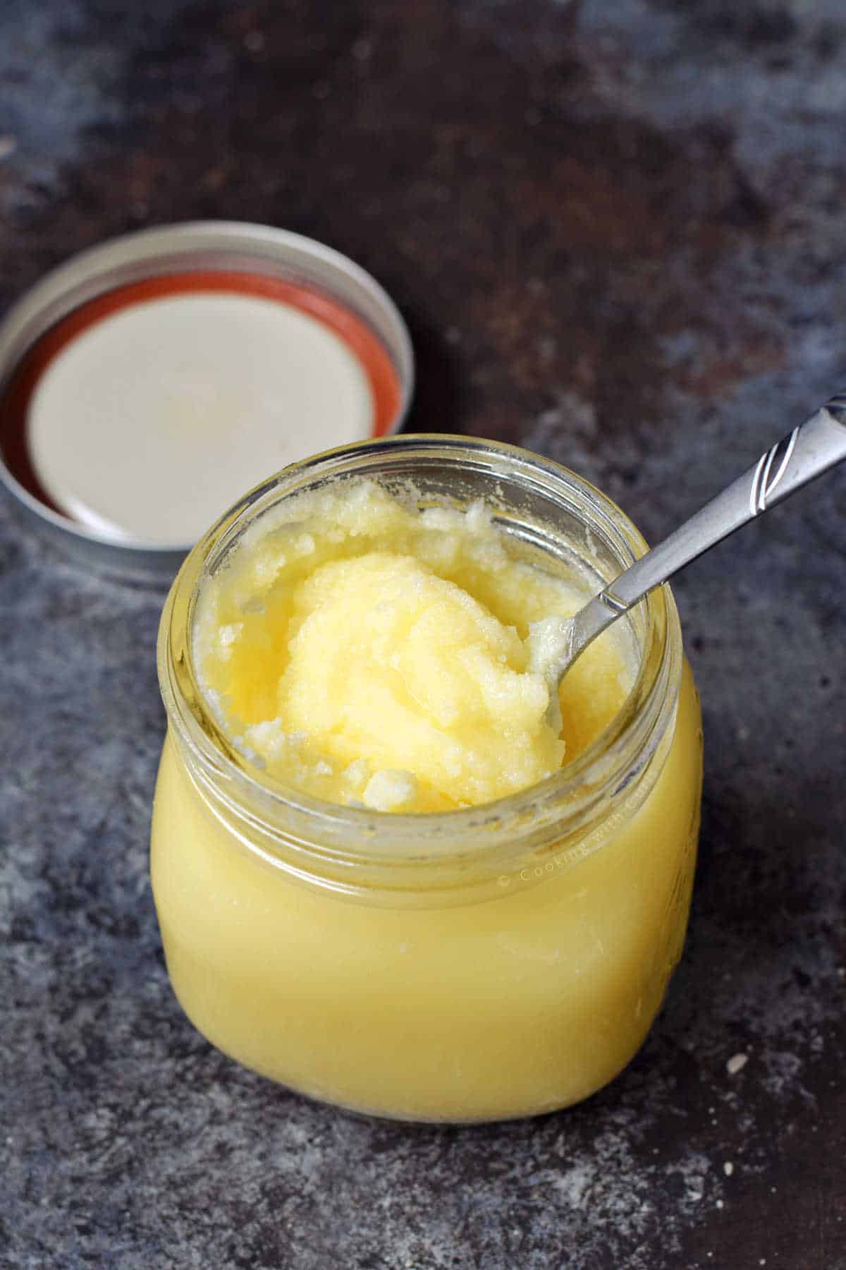 Clarified butter in a small jar with a spoon.
