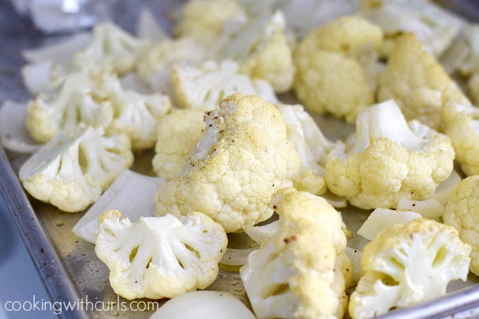 Roasted cauliflower pieces on a baking sheet.