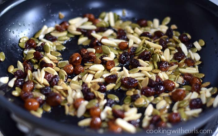 raisins, almonds, and pumpkin seeds to the oil in the skillet.