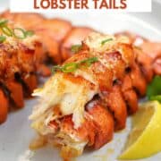 Two broiled lobster tails with lemon wedges on a plate with title graphic across the top.