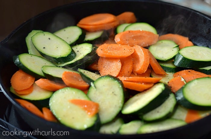 Sliced Zucchini and Carrots in a cast iron skillet.